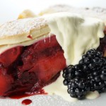 A slice of the pie with cream and berries