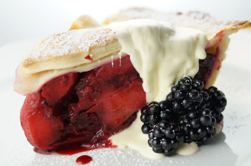 A slice of the pie with cream and berries